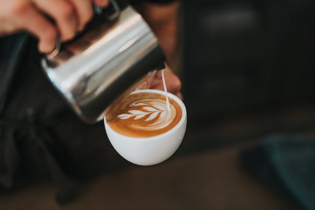 Pouring milk into coffee - The best time of the day to drink coffee as a student - Magnet.me blog en 